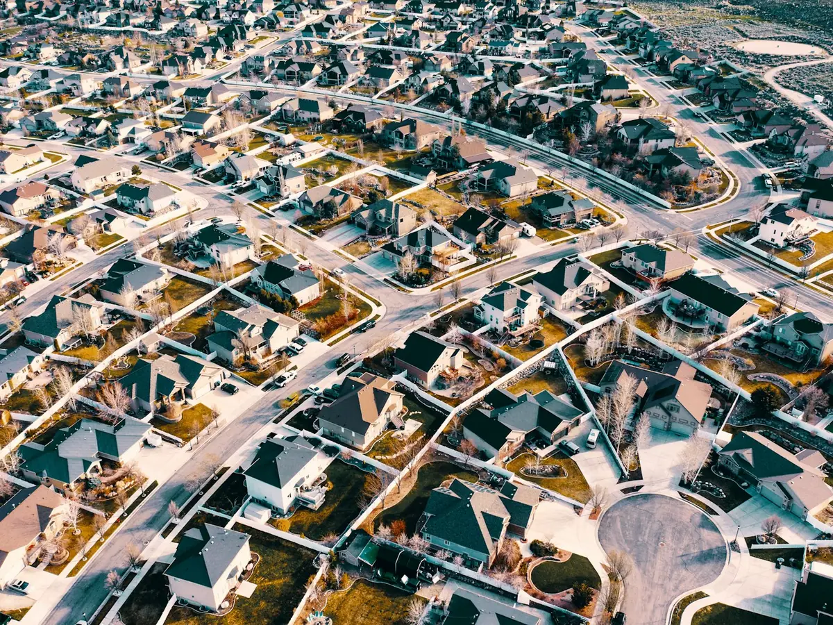 Aerial view of a dense subdivision of similar homes on curving streets and cul-de-sacs