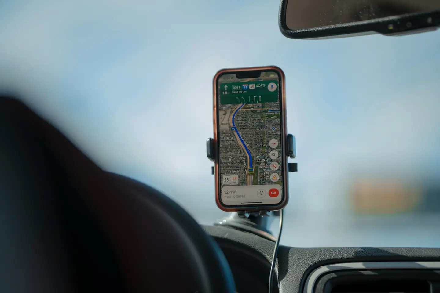 A phone in a dashboard mount showing a navigation route